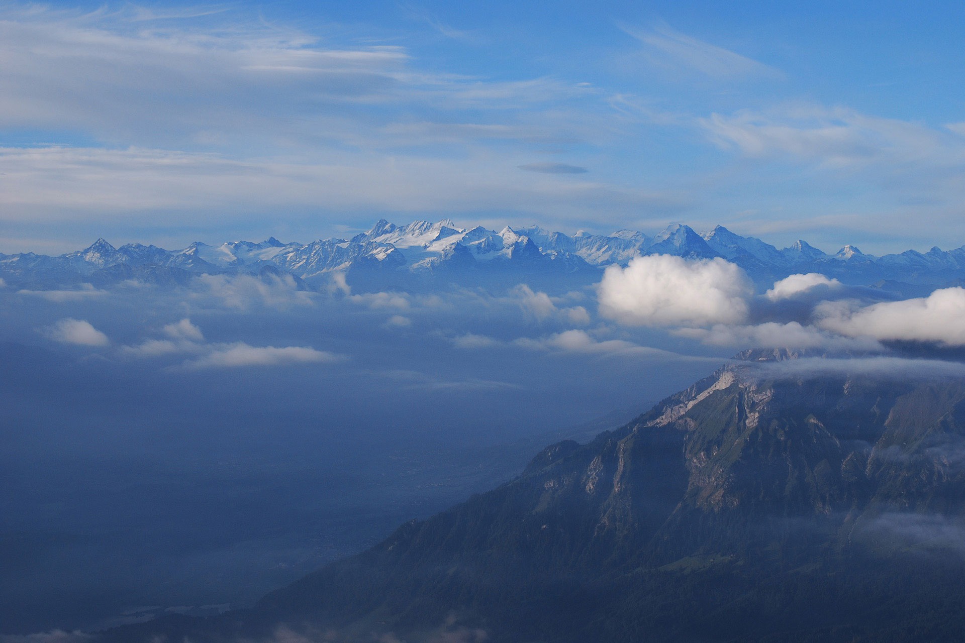 Blick über den Pilatus zu den Berner Alpen an einem klaren Sommermorgen.